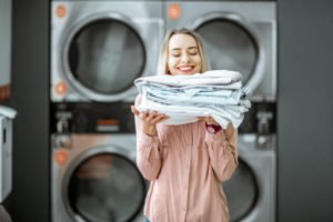 woman holding folded clothes